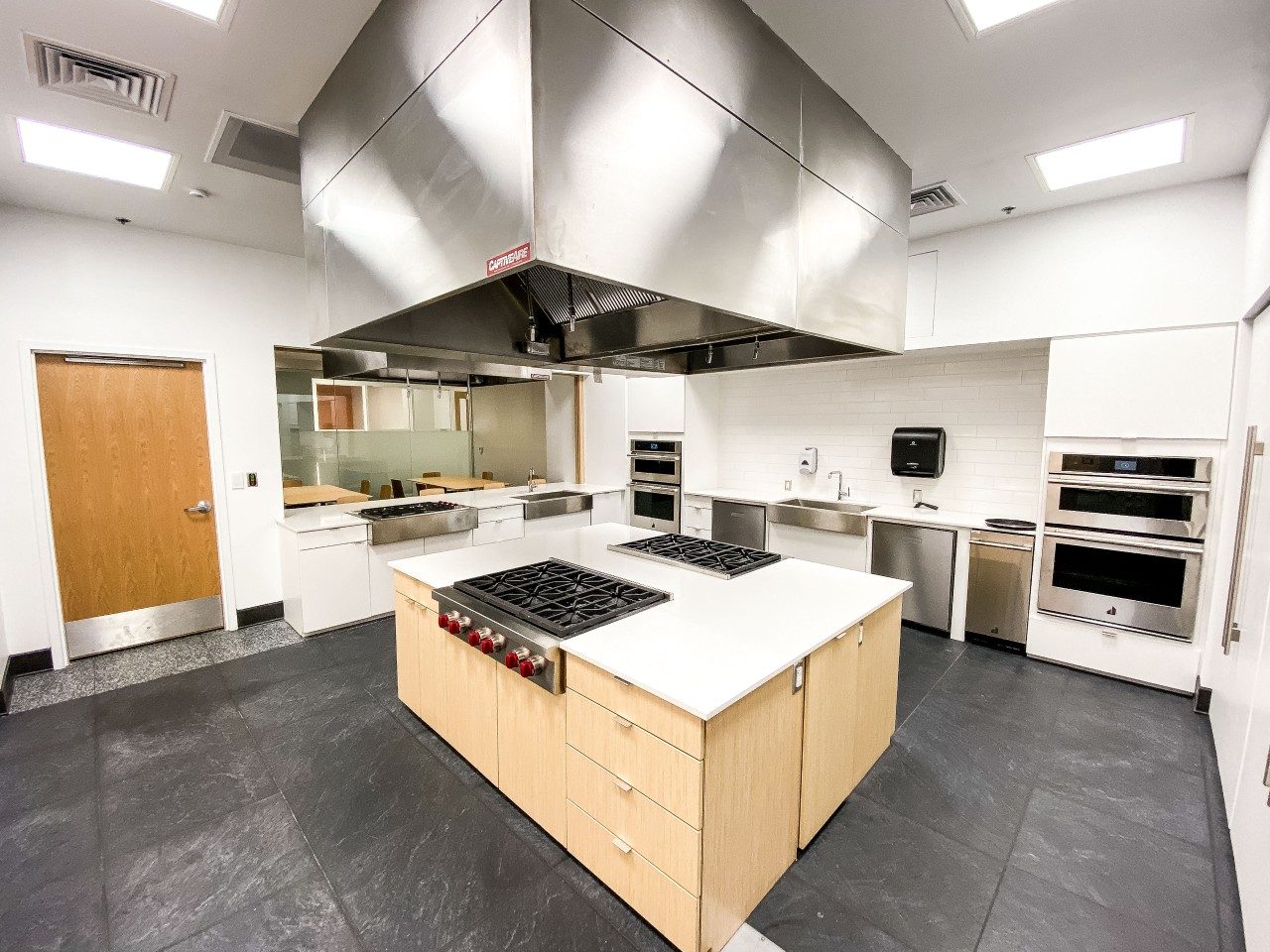 The metabolic kitchen features commercial-grade cooking facilities, including 16 stove burners, four ovens, two dishwashers, kitchen appliances, utensils and cookware, Nutrition Data System for Research access, and a dining and observational area