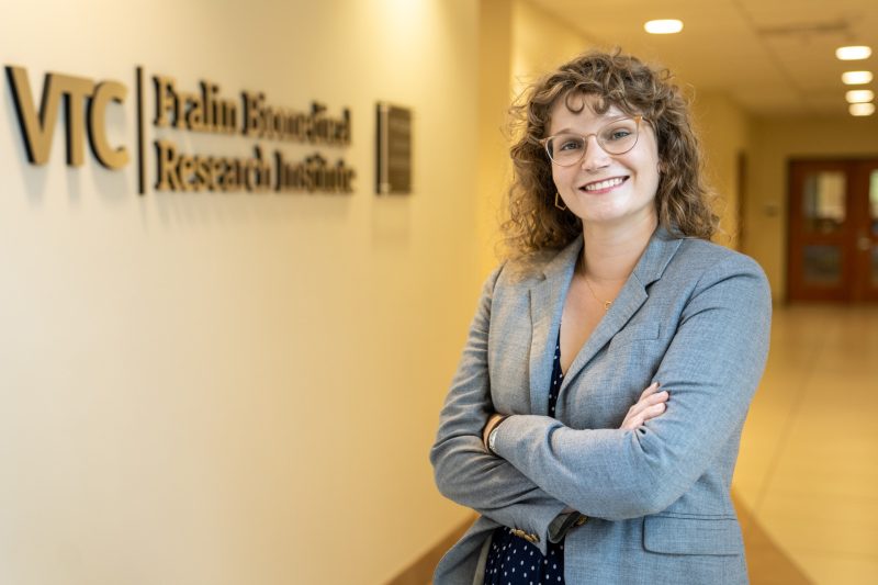 woman with brown curly hair in front of FBRI logo