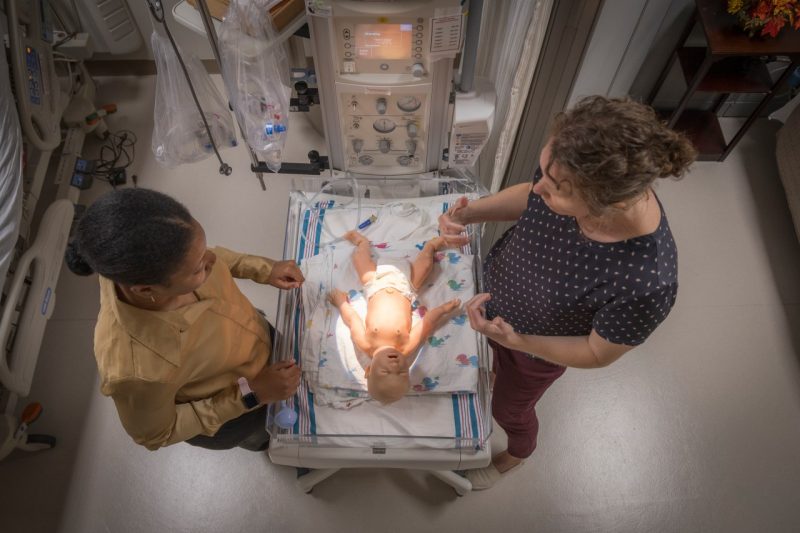 A student and a faculty member work in a simulation lab.