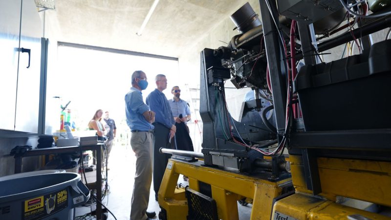 (From left) Wing Ng, Brian Warner, and Todd Lowe stand at the Rolls-Royce engine used for research in the Virginia Tech Advanced Power and Propulsion Laboratory.